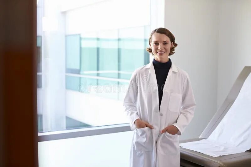 Portrait of an Attractive Young Female Doctor in the White Coat. Stock Image - I