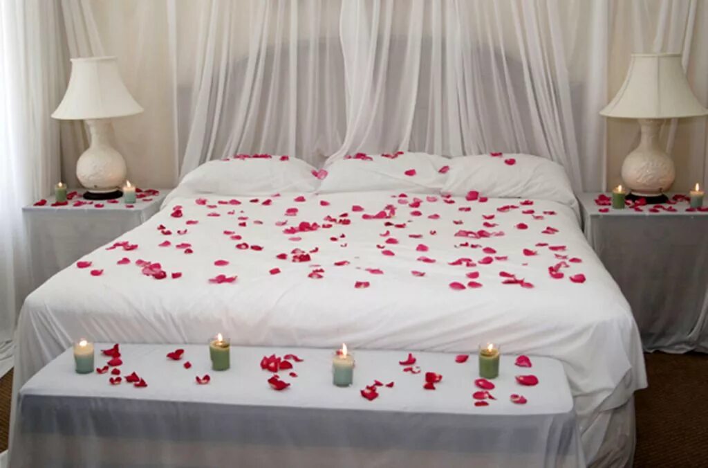 Романтичная постель. Кровать для новобрачных. Спальня для молодоженов. Лепестки роз на постели. Романтическая кровать.