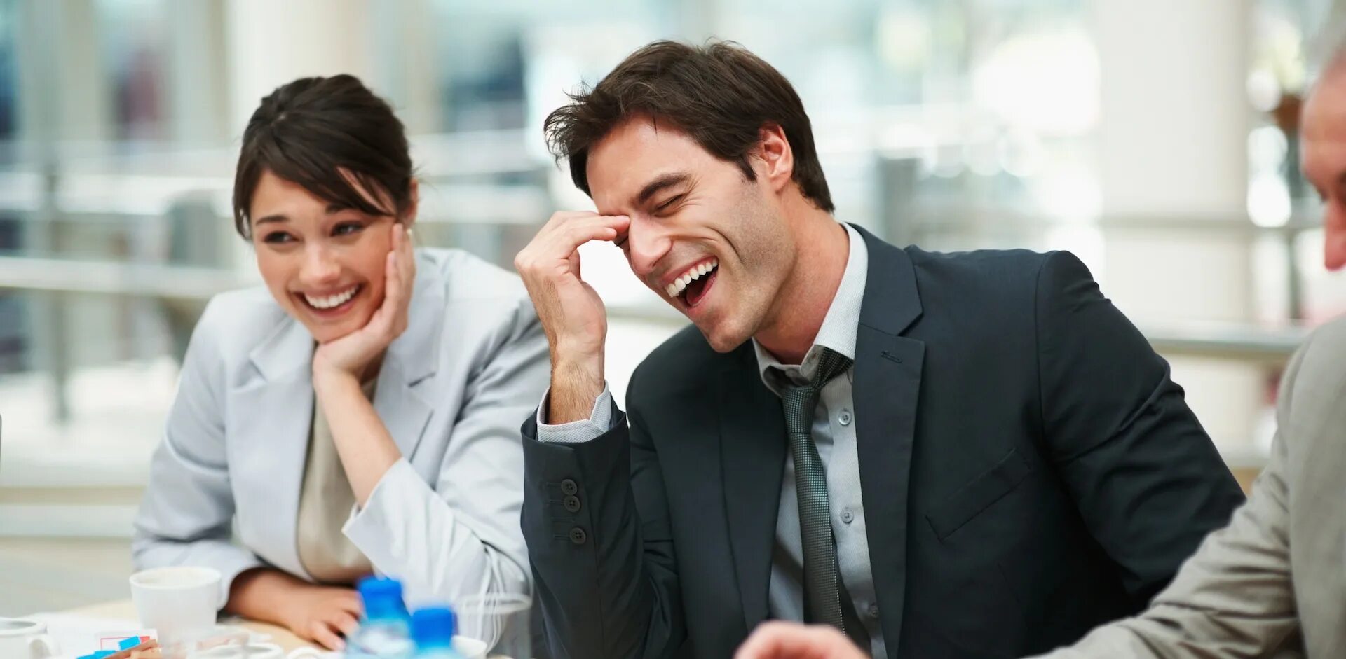 Друзья шутят друг над другом. Коллеги смеются. Веселые люди в офисе. Смех в офисе. Сотрудники смеются.