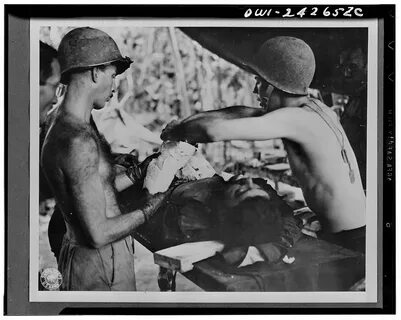 wounded in the arms and shoulders by shrapnel from a Jap mortar as he was s...