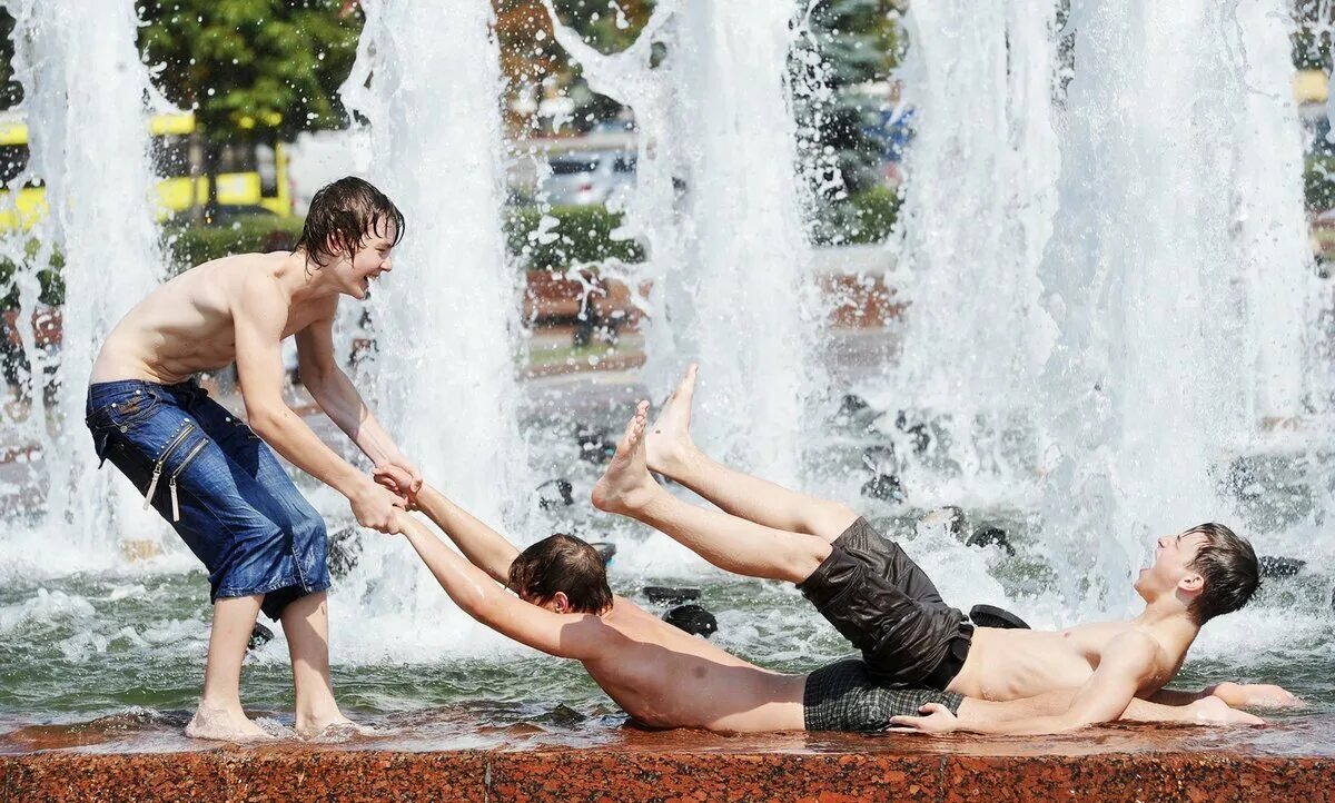 Жара дети купаются в фонтане. Купание в фонтане. Люди у фонтана. Мальчик в фонтане. Жара купаться