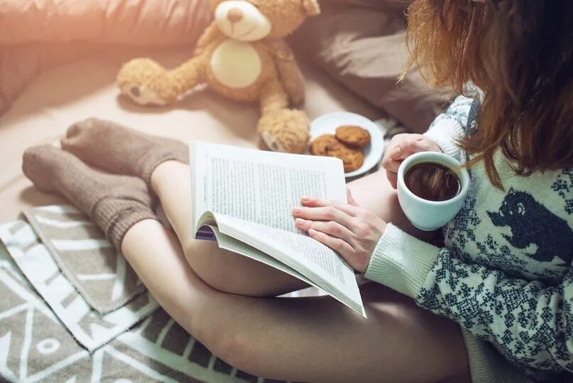 Читаю книги пью кофе. Девушка читает книгу. Девушка читает книгу и пьет кофе. Девушка в свитере за столом. Стол девушка книги.