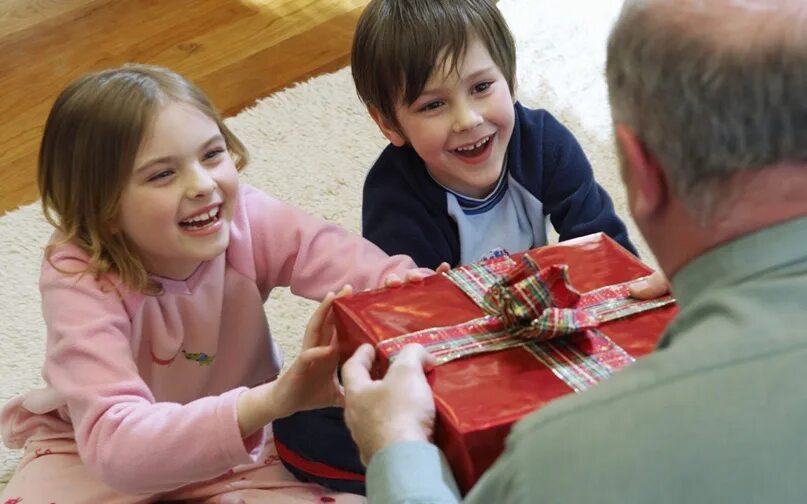 Подарки для детей. Ребенок дарит подарок. Радость ребенка от подарка. Человек дарит подарок.