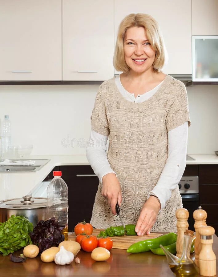 Женщина готовит из овощей. 60 Летняя женщина на кухне готовит реланое. Housewife Cooking.