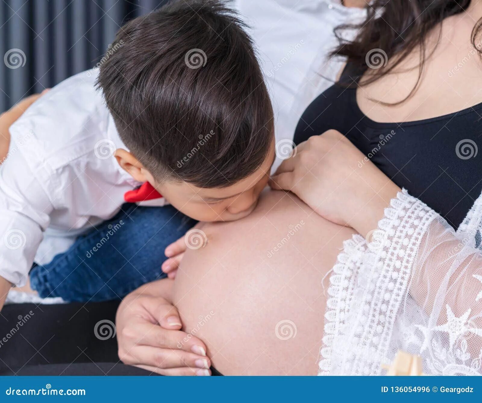 Потрогать мамину. Девочка целует живот беременной мамы. Мальчик целует живот беременной. Материнская грудь. Ребенок целует беременный животик.