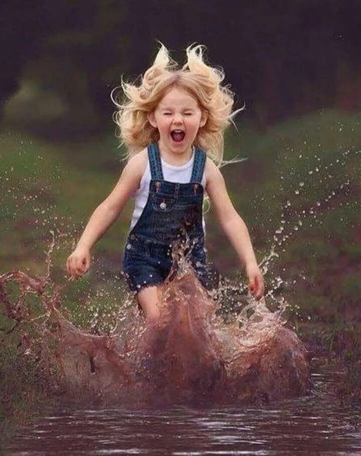 Девочка прыгает в лужу. Маленькая девочка бежит. Счастливое детство лужи. Дети по лужам.