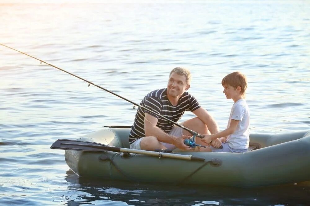 Папа с сыном у речки. Отец с сыном в лодке. Отец и сын рыбачат на лодке. Отец с сыном на рыбалке на речке.