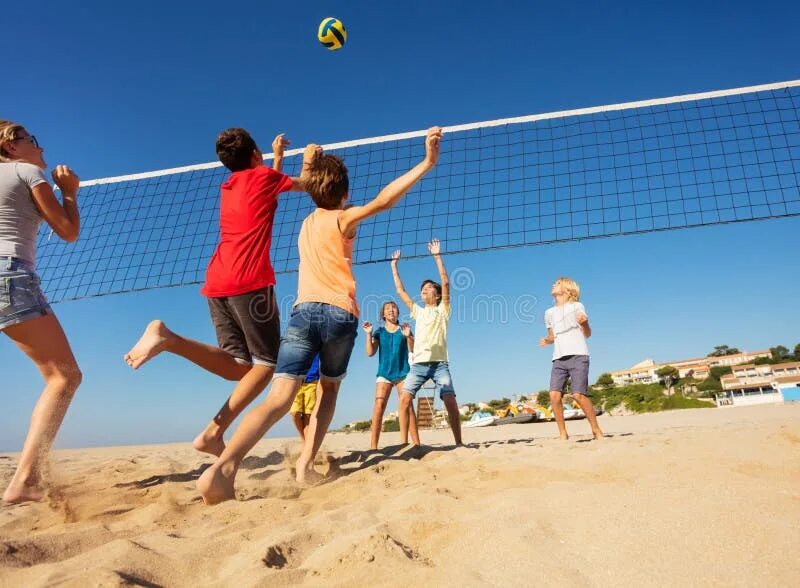 Playing volleyball is fun. Teenagers on sport bars. Пляжный волейбол спорт. Playing volleyball is fun. Играть в мяч.