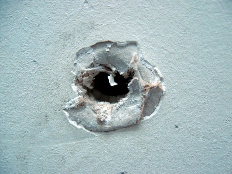 В стене дыра в дыре глаза. Дыра в стене. Большое отверстие в стене. Дыра в железобетонной стене. Дырочки в бетонной стене от насекомых.