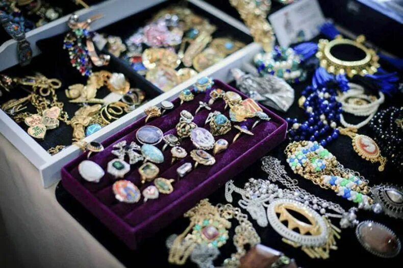 Выкладка бижутерии на ярмарке. Ювелирная выставка. Старинная бижутерия. Много украшений. Индийские товары.