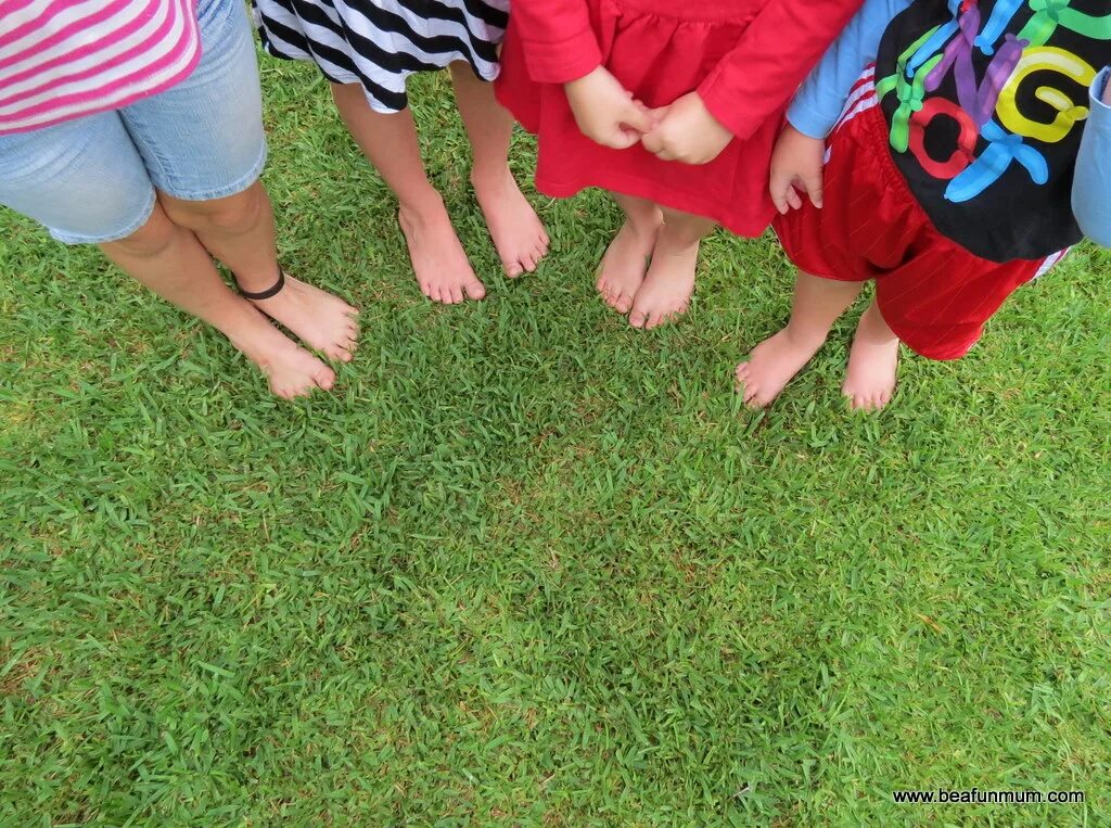 Kids feet Challenge. Baby girl barefoot grass. Barefoot Top view. Feet Chop Kids.