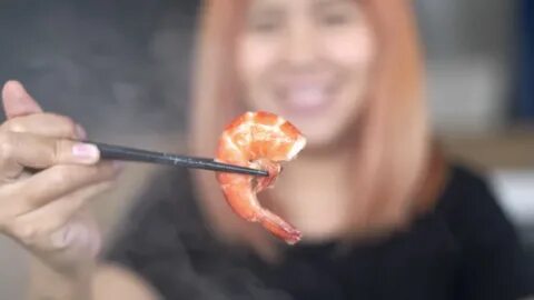 Человек ест креветки