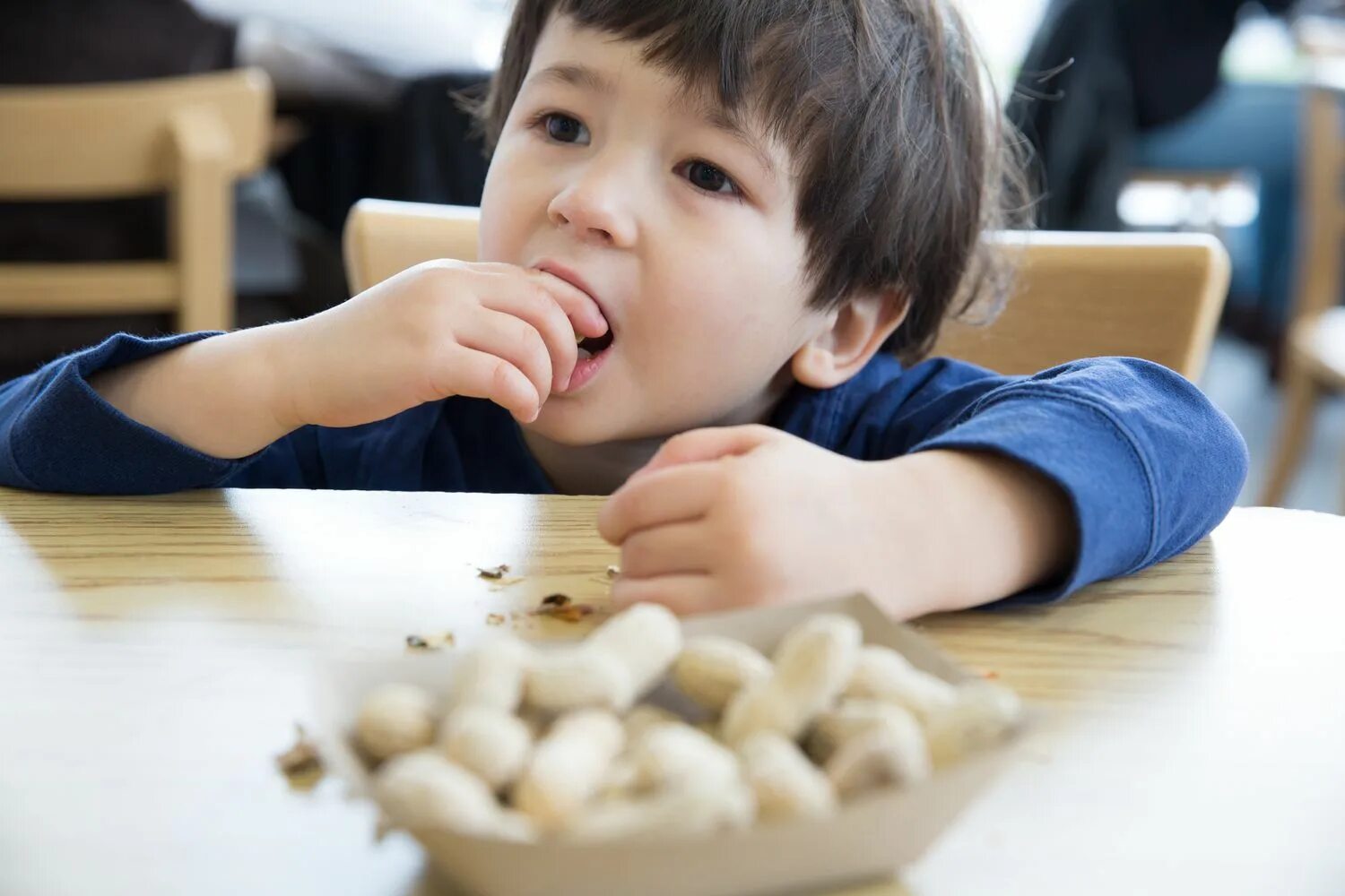 Ребенок ест орехи. Орех для детей. Мальчик с орехами. Человек ест арахис.