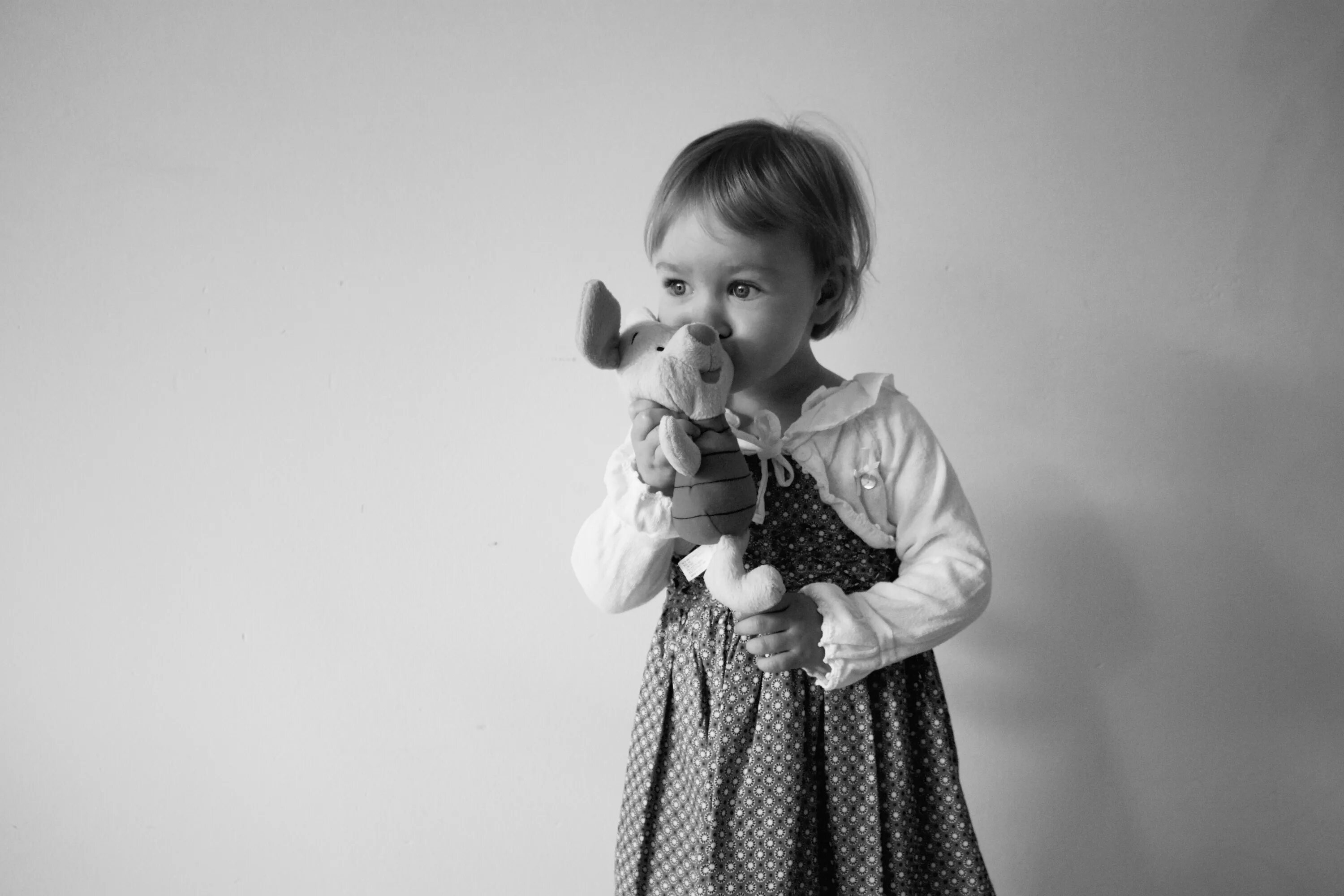 Маленький ребенок чб. Портретная детская фотосессия с игрушкой. Малыш на темном фоне. Фотосъемка детей на черном фоне.