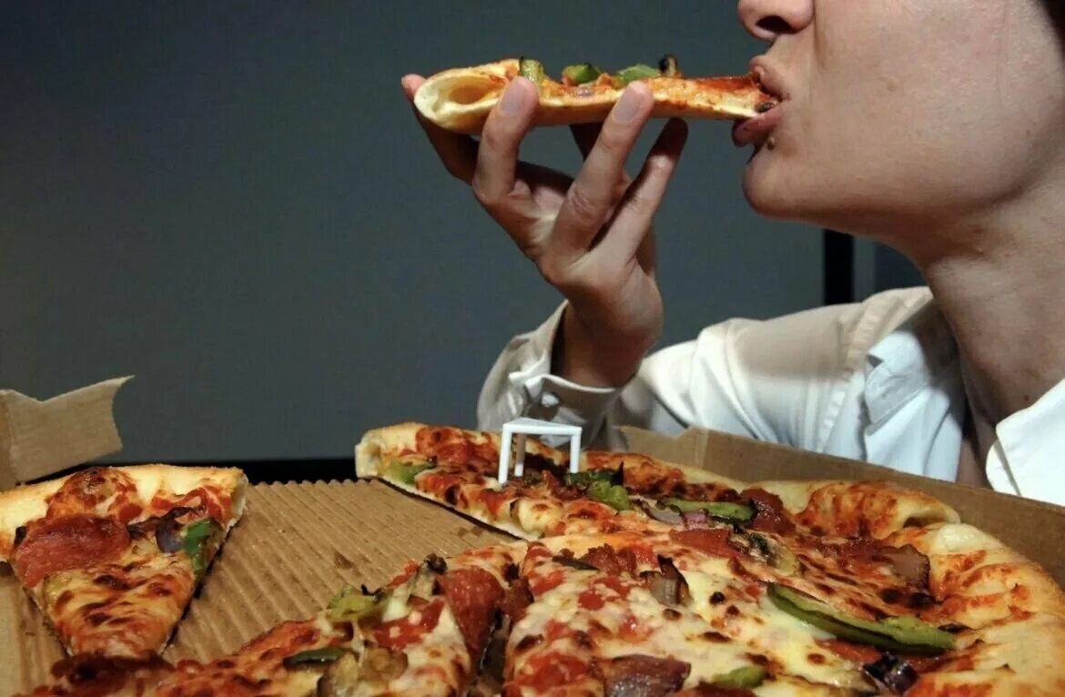 Где едят людей. Кушает пиццу. Люди кушают пиццу. Люди в пиццерии. Пицца в руке.