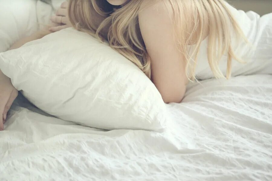 Девушка блондинка на кровати. Блондинка на кровати со спины.