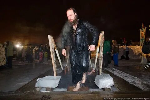Священник в проруби на крещение