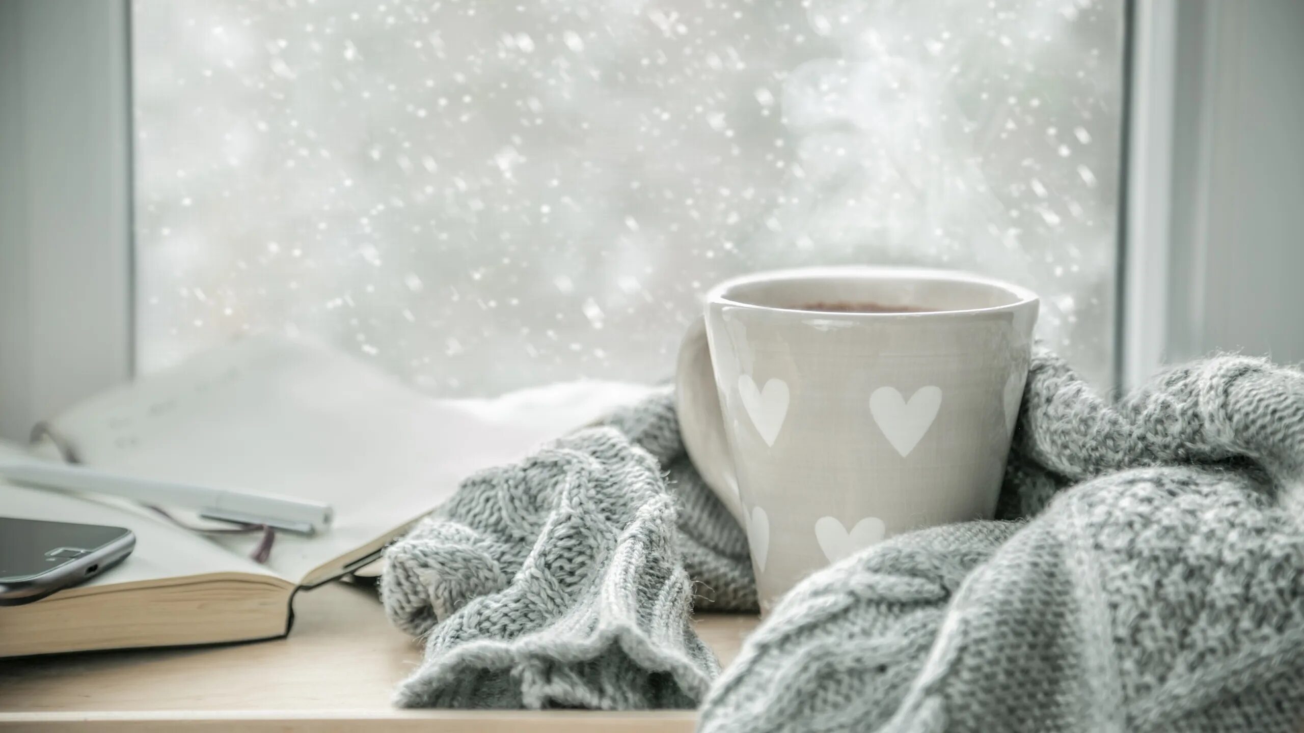Утро туманно украшена снежинками книги собраны. Чашка кофе на заснеженном окне. Чай зимой. Чашка кофе на зимнем окне. Зима чай уют.