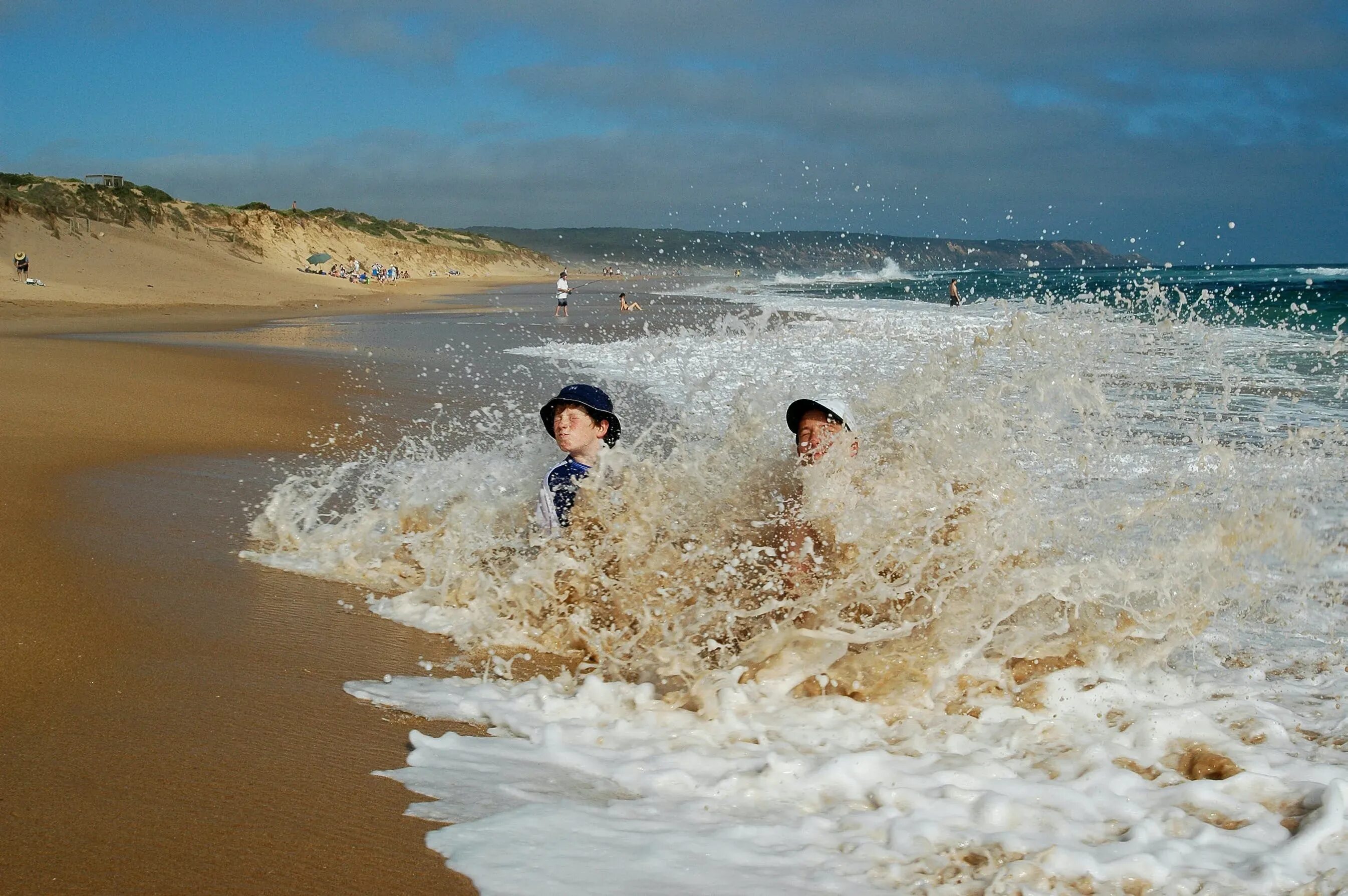 Волна пляж дети. Отдых на воде. Волна накрывает отдыхающих на пляже. Мама где море
