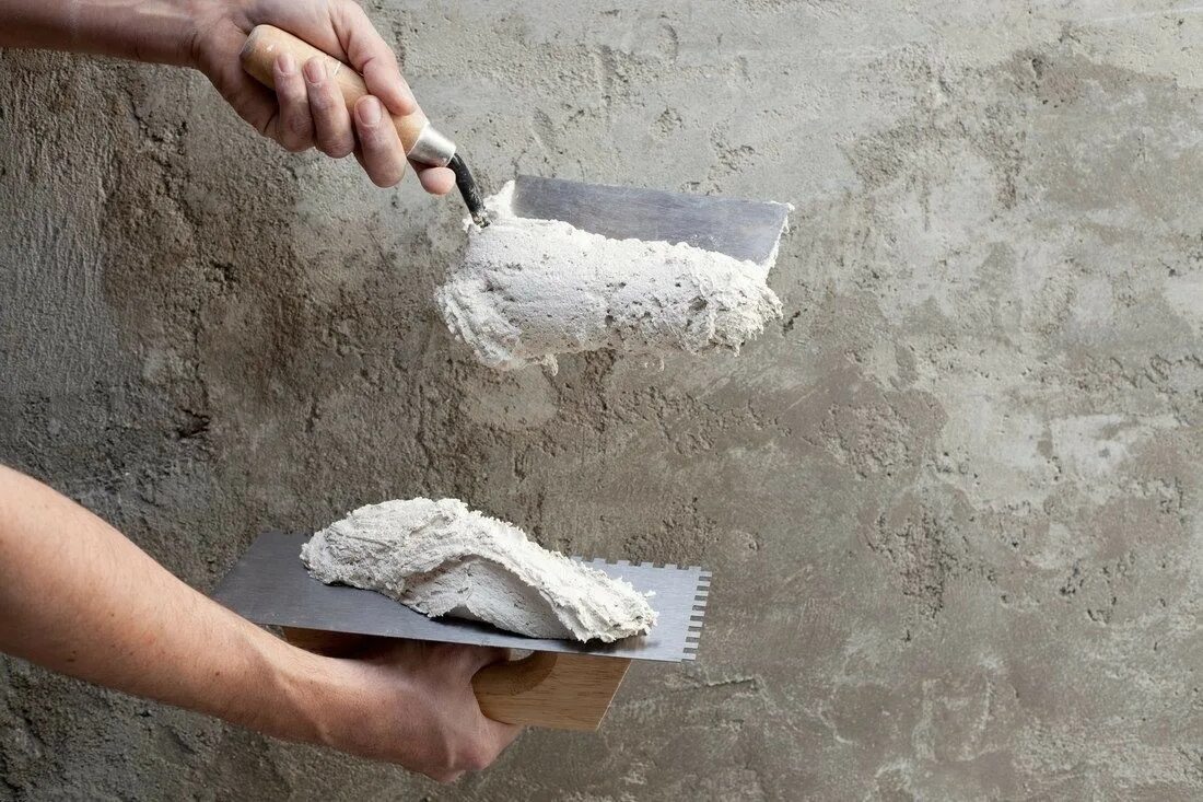 Стоит шпаклевка. Известково Песчаная штукатурка. Цементная штукатурка на стене. Штукатурка стен известковым раствором. Нанесение раствора на стену.