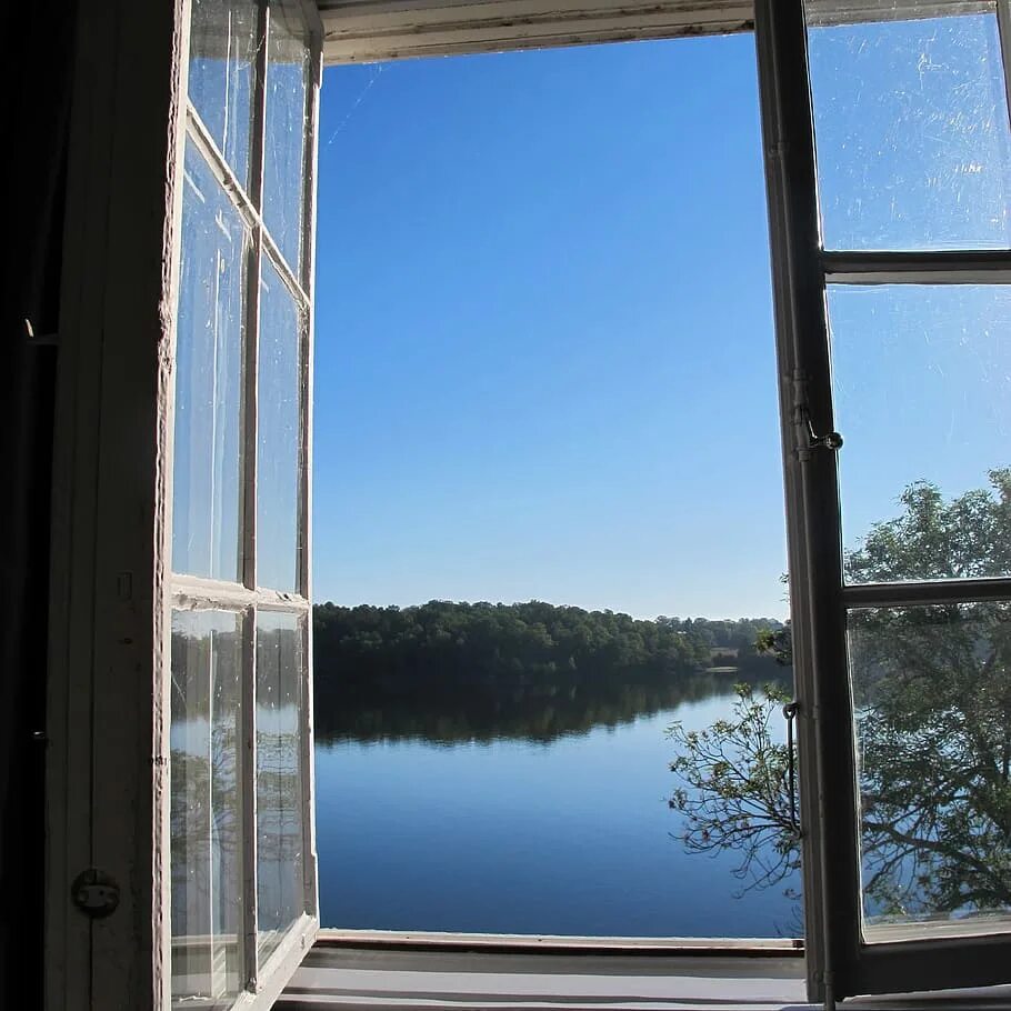 В оконной раме голубеет квадратик чистого неба. Вид из окна на озеро. Небо в окне. Окно картинка. Озеро в окне.