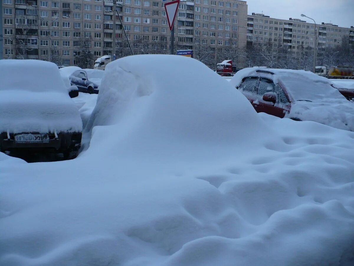 Машина под снегом. Много снега в городе. Машина завалена снегом. Машина в сугробе.