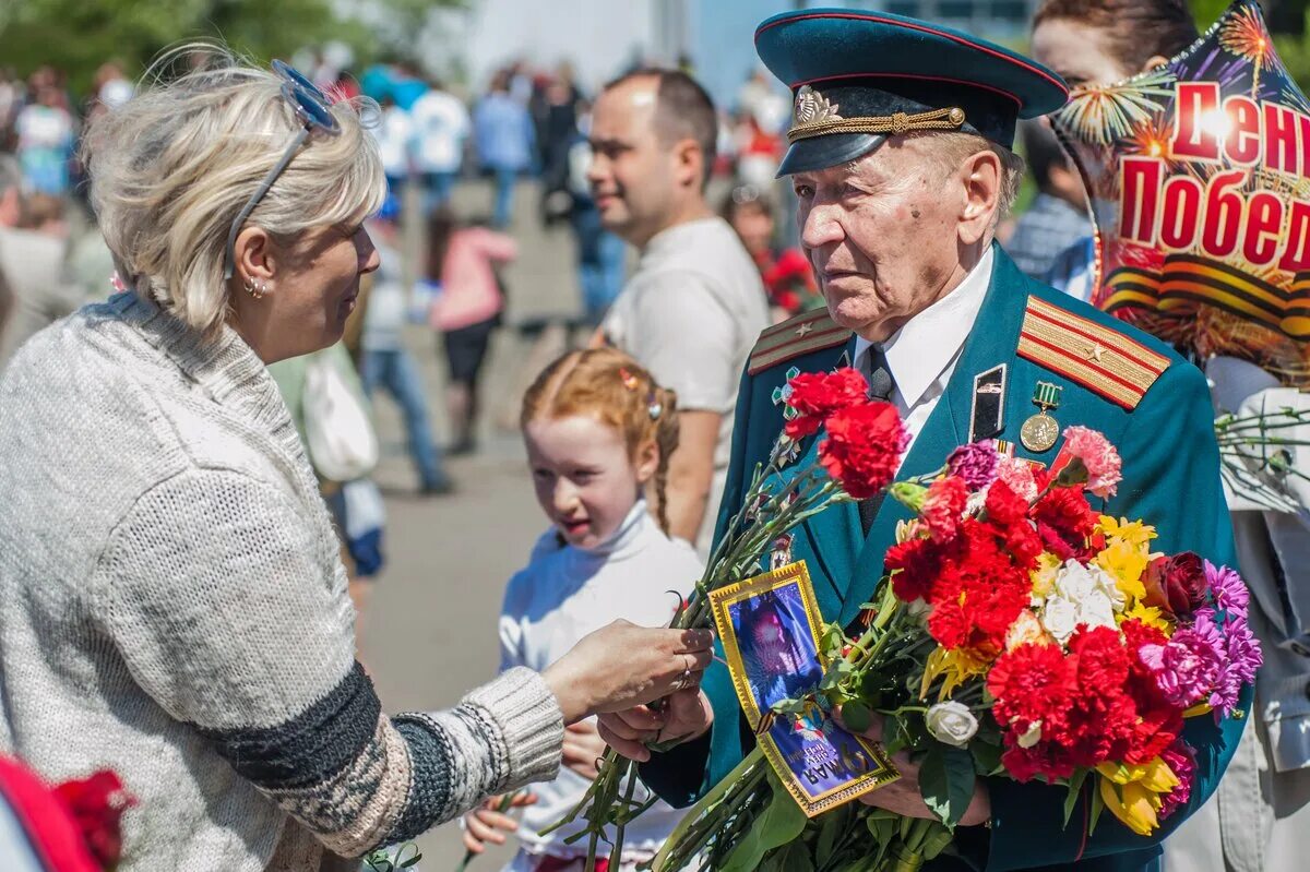 Цветы ветеранам. Ветеранам дарят цветы. День Победы ветераны. Гвоздики ветеранам.