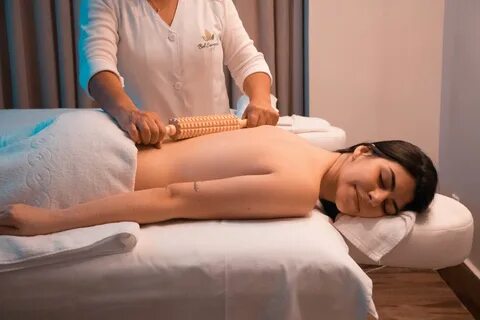 Woman in white salon uniform massaging client.