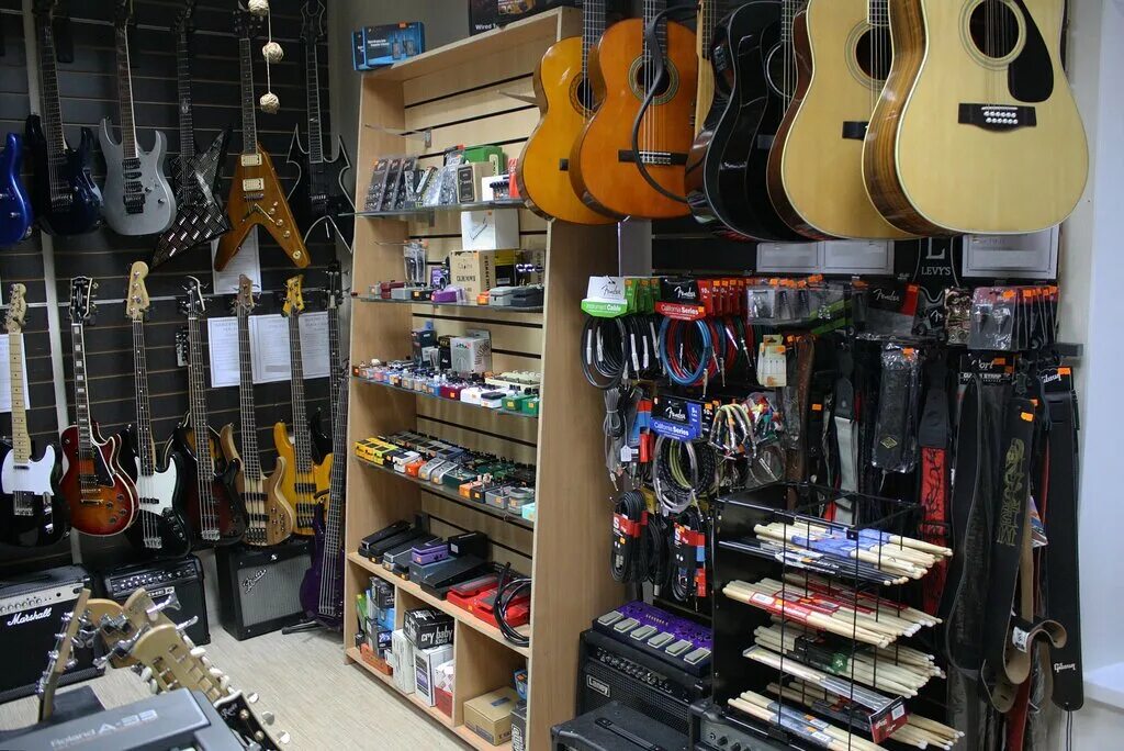 Куплю гитару адреса магазинов. Гитарный магазин. Музыкальный магазин. Гитары музыкальные магазины. Витрина для гитары.