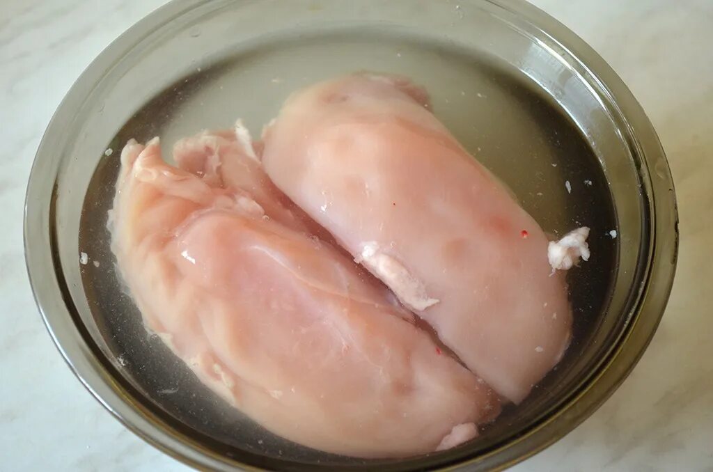 Замочить куриную грудку. Распластать грудку куриную. Куриная грудка вымоченная в соленой воде.