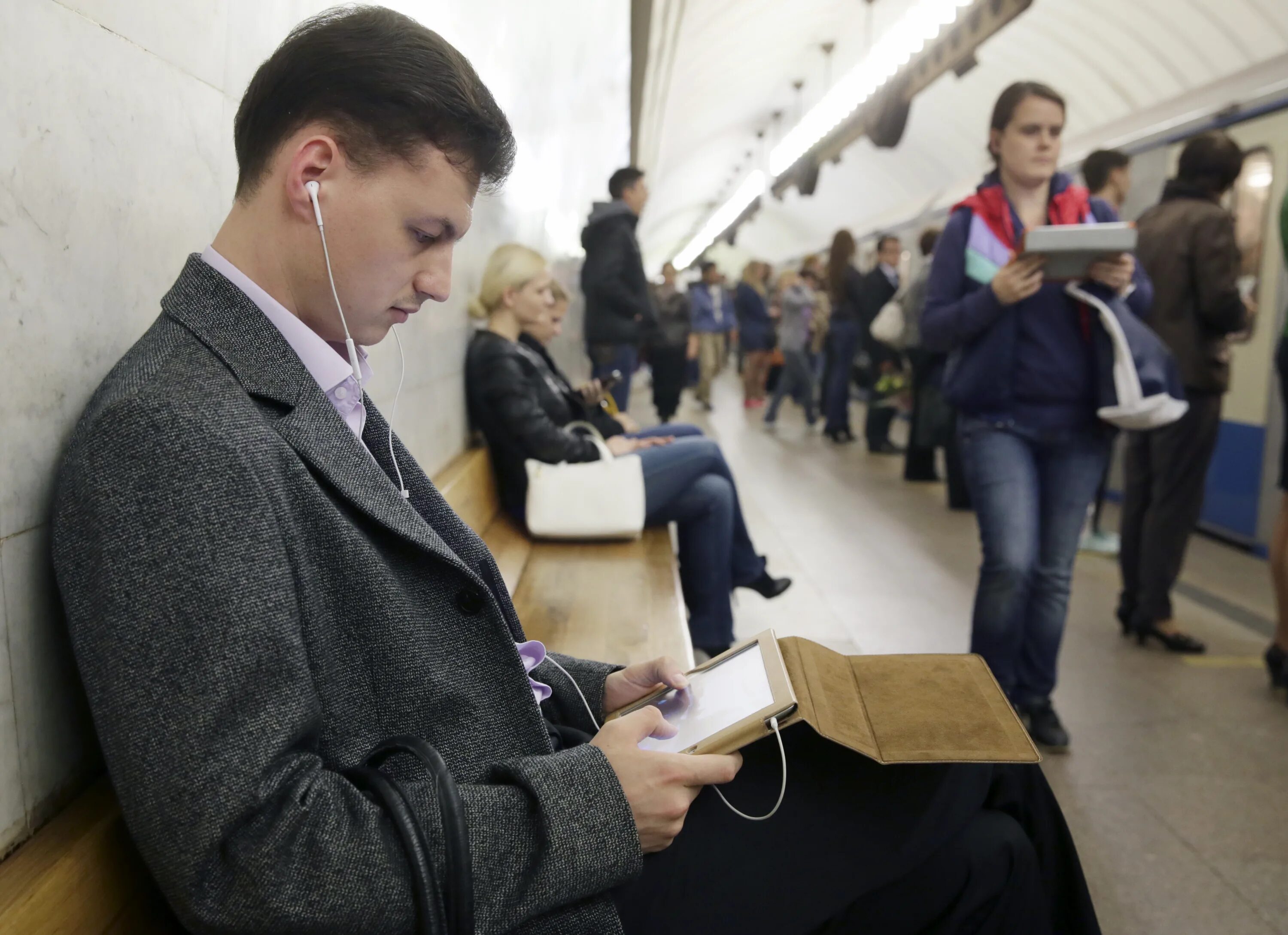 Проходить в метро по телефону. Люди в наушниках в метро. люди в метро с телефонами. люди со смартфонами в метро. парень с телефоном в метро.