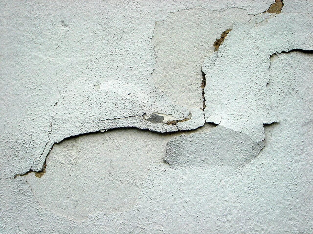 На стене появились трещины. Усадочные трещины в штукатурном слое. Усадочные трещины в штукатурном слое, частичное отслоение штукатурки. Отслаивание штукатурки. Потрескавшаяся штукатурка.