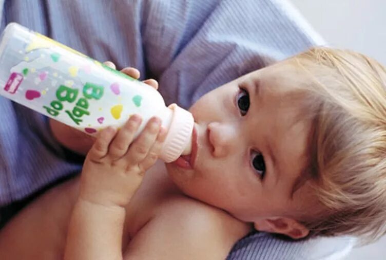 Ребенок с бутылочкой. Докорм ребенка. Малыш пьет из бутылочки. Маленький ребенок пьет из бутылочки. Как отучить от бутылочки ночью