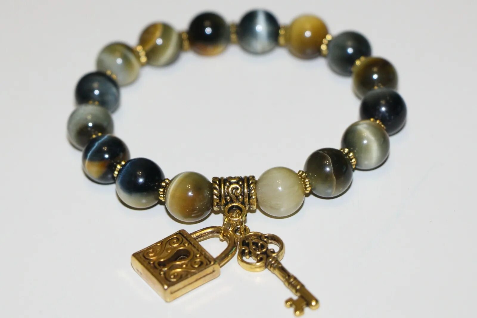 соколиный глаз кому подходит по знаку. тигровый соколиный глазглаз камень. ястребиный глаз камень. кварц соколиный глаз. тектит украшения.