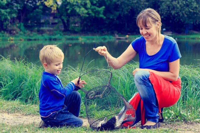 Мама на рыбалке. Девочка держит рыбу. Рыбалка с сыном. Мама рыба.