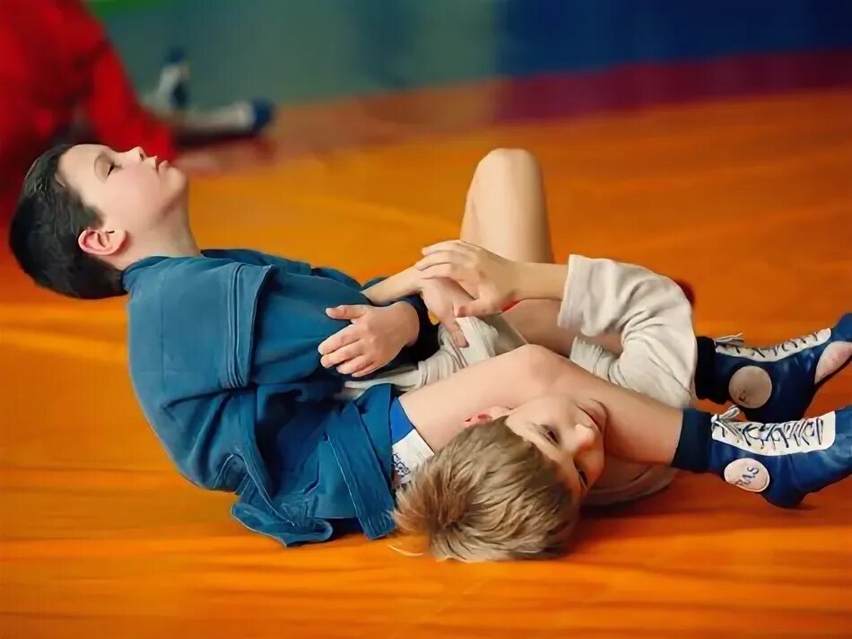 Детский грепплинг. Мальчик босиком борьба. Друзья борются. Девочка с мальчиком борятся на траве. Уроки драки самбо.
