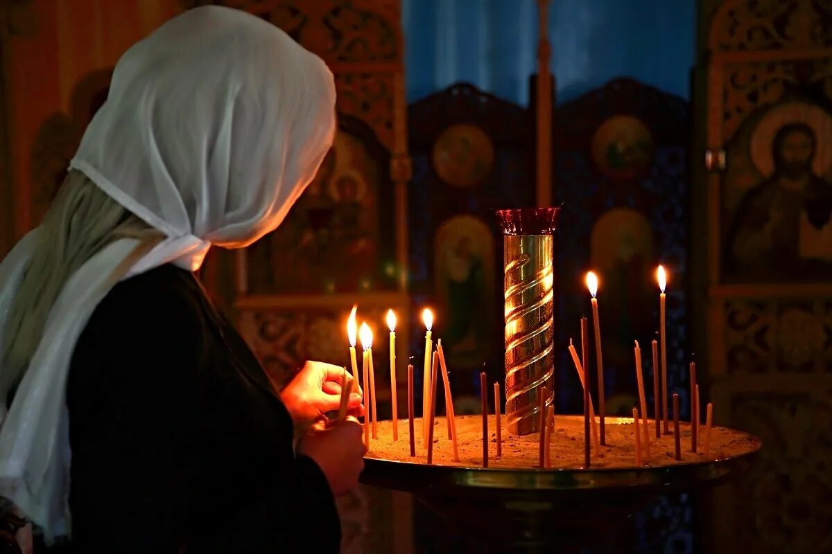 Свечи в церкви. Девушка молится в храме. Женщина со свечой в храме. Девушка в храме.