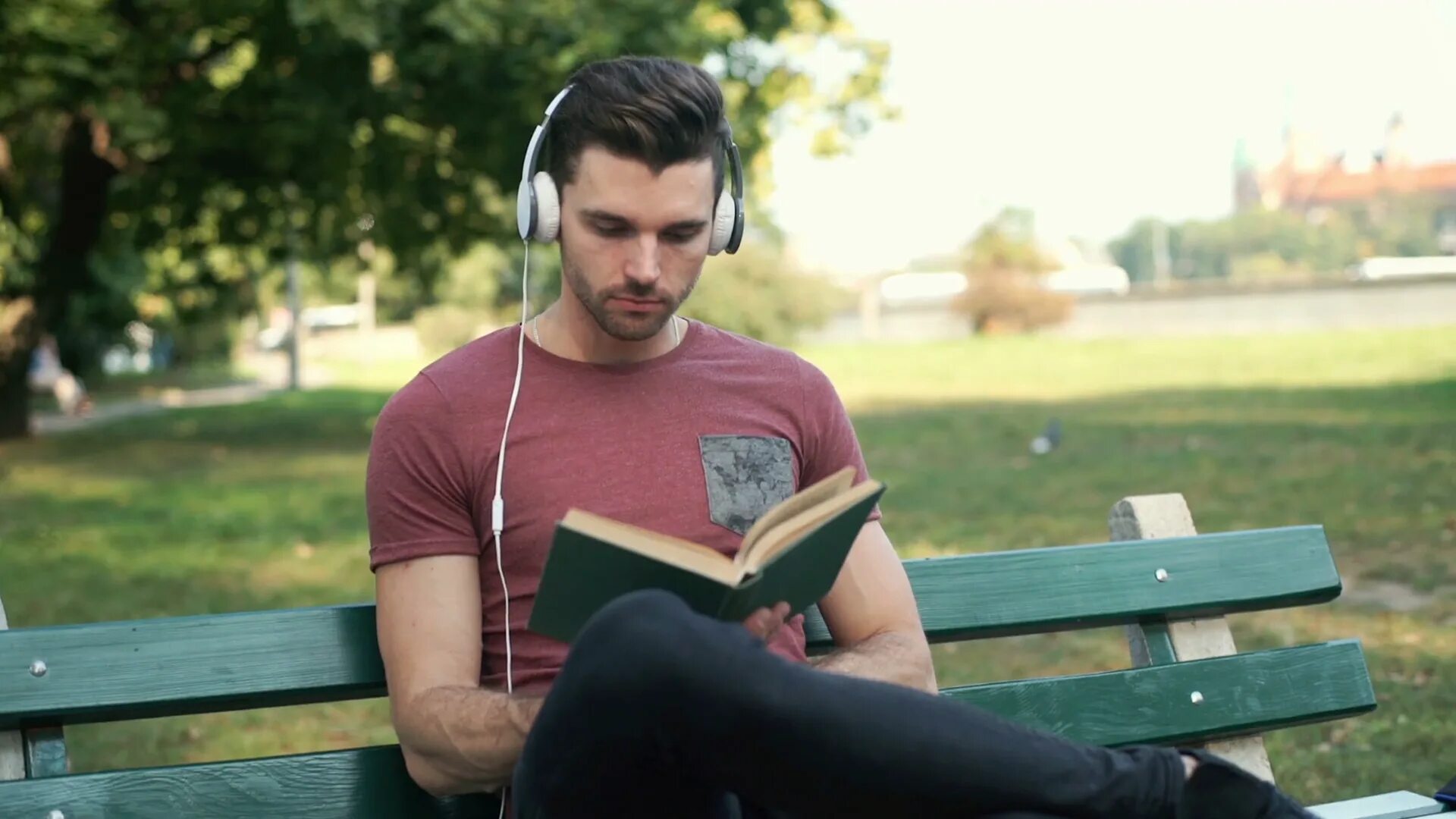 While listening to music. Wireless headphones on a person. listening and reading book. handsome guy listening to music. reading book listening to music.