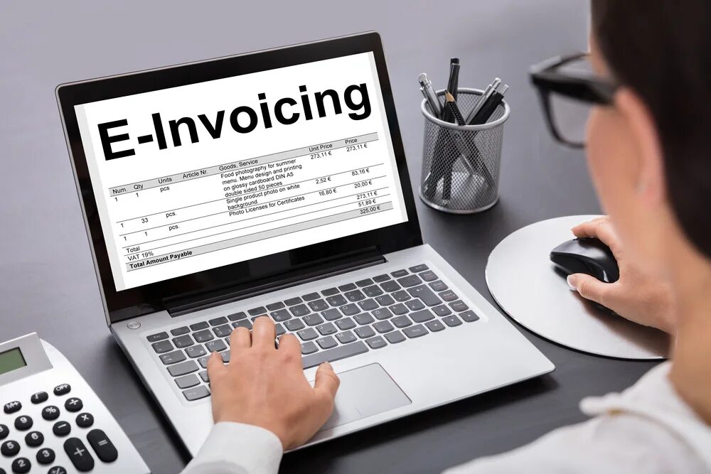 E archive. Invoicing. Invoice and Laptop. Ноутбук и калькулятор на столе врача. Electronic Invoice.