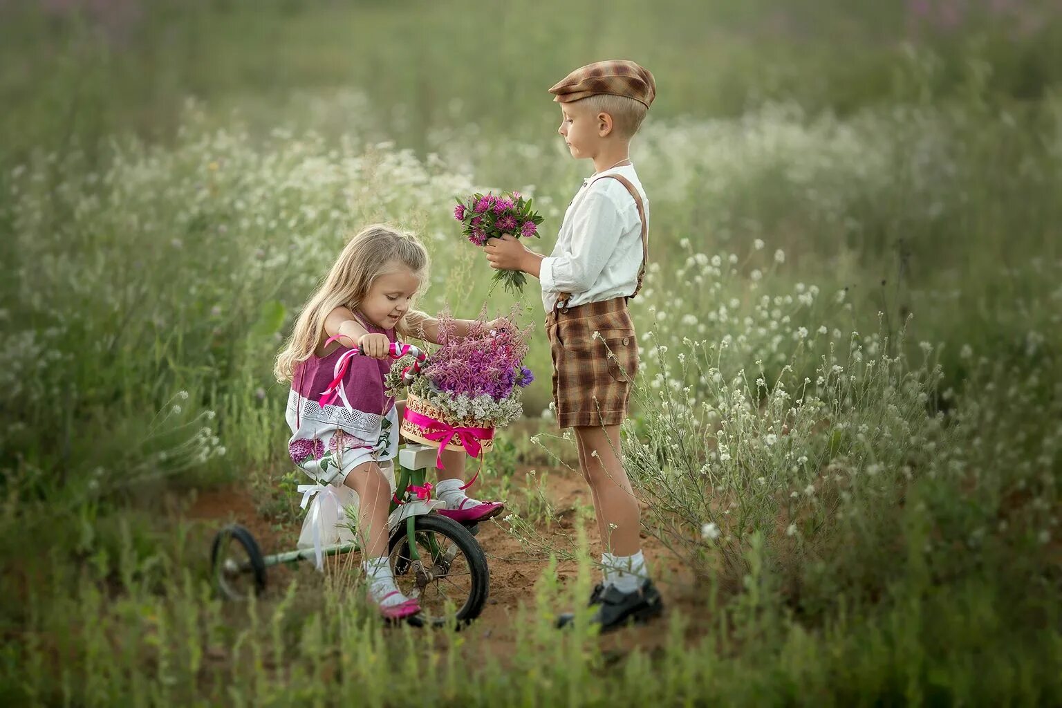 Мальчик дарит девочке цветы. Дети и природа. Мальчик Дари девочке цветы. Девочка летом.
