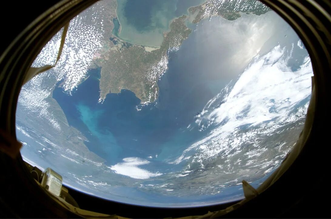 Увидев в иллюминаторе голубую землю. Крымский полуостров вид из космоса. вид из иллюминатора космического корабля. иллюминатор космос. земля в иллюминаторе.