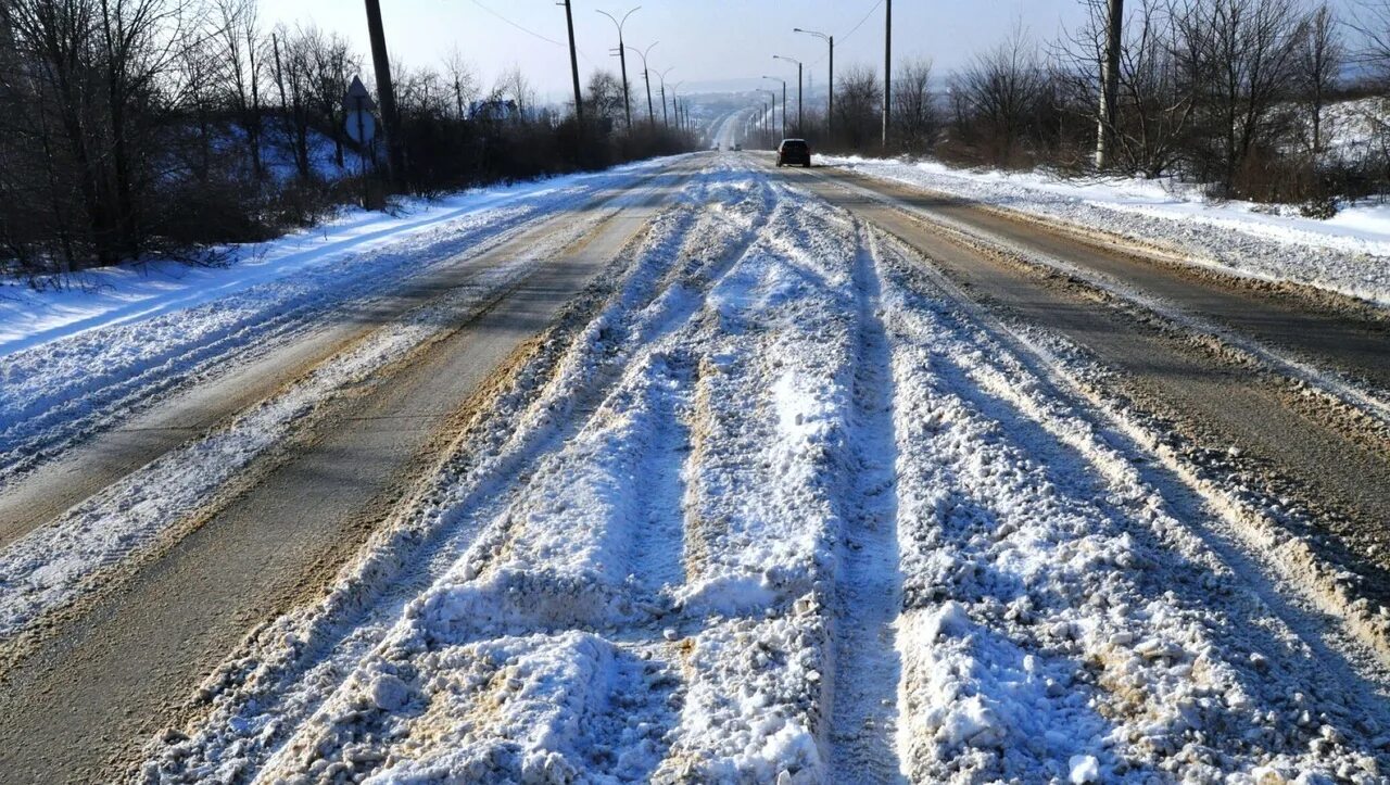Дорогу в глубоком снегу. Снег на дороге. Снежная колея на дороге. Занесенная снегом дорога. Колейность зимой на дороге.