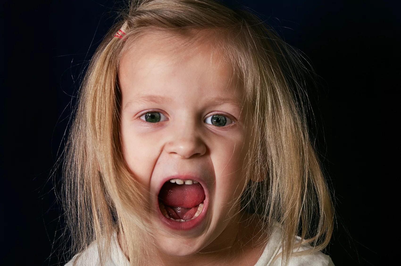 девушка держит во рту. маленькая девочка открыла рот от удивления. еда во рту маленькой девочке. девочка с открытым ртом. смешные дети.