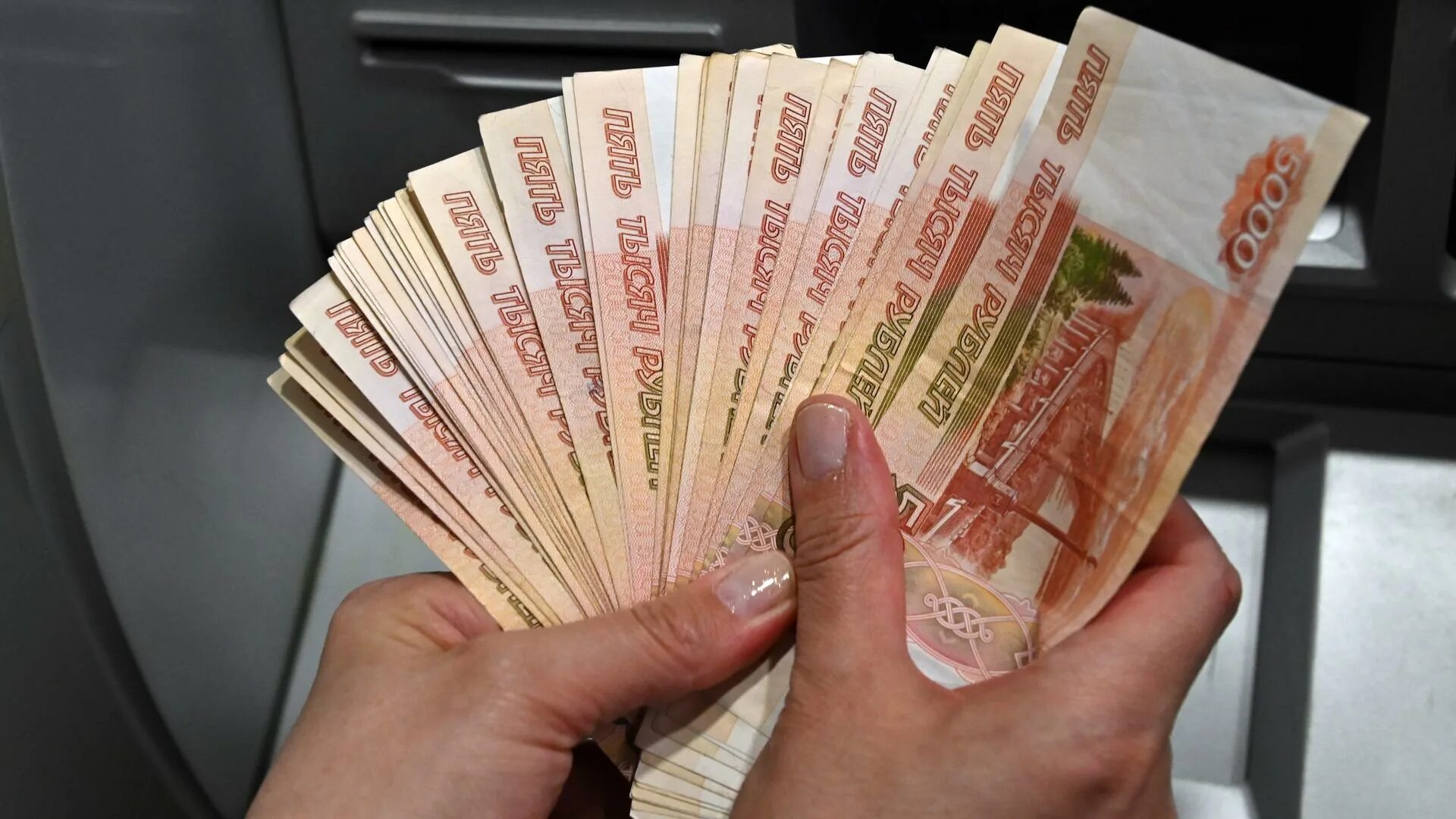 Выплата погорельцам. 68 миллионов рублей. Пачка купюр на столе. Много денег на столе. Пачка купюр на столе.