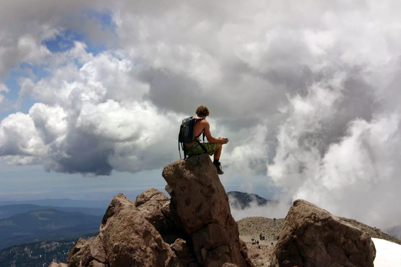 Человек на обрыве скалы. Парень вдалеке на горе. Человек на обрыве скалы. Разговоры прекращены все смотрят на скалу. Разговоры прекращены все смотрят на скалу.