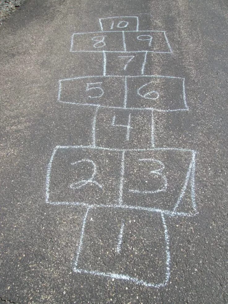 Hopscotch Game Being Drawn with a Chalk on the Asphalt Ground As Seen from Above