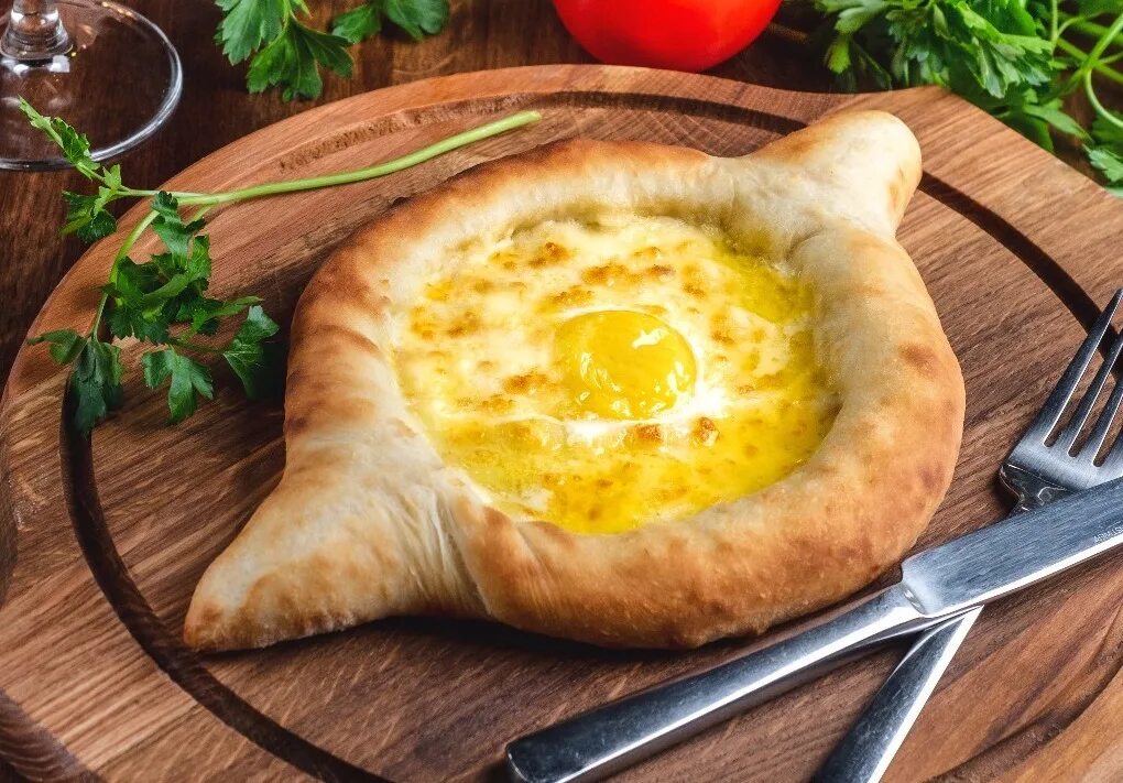 Хачапури по-аджарски 300г. Ачарули хачапури. Кавказская кухня хачапури по аджарски. Грузинский хачапури по аджарски. Настоящая хачапури по аджарски.