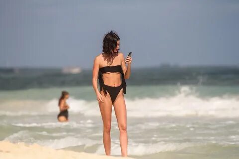 Beach babe Bella Banos sinks her toes in the Mexican sands of Tulum while e...