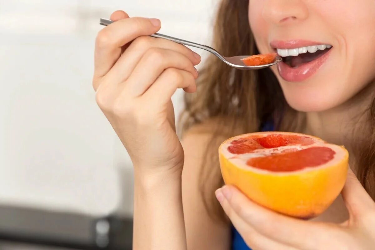 Горечь во рту и пища. Девушка ест грейпфрут. Девушка ест фрукты. Полезная пища для зубов. Человек ест фрукты.