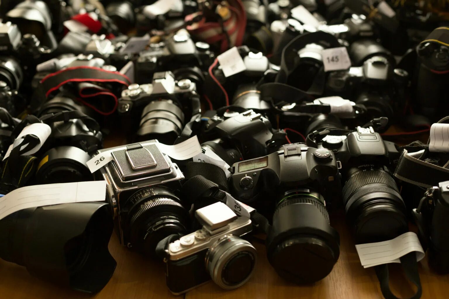 Camera used can be used. Camera on the table. a lot of cameras. many cameras on the ground. photo camera on the table.